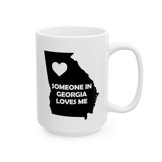 White mug with black silhouette of Georgia and heart, text 'SOMEONE IN GEORGIA LOVES ME' on a white background