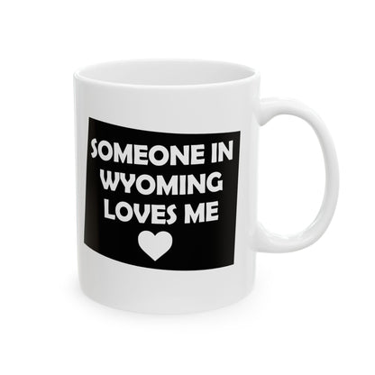 White mug with a black label that says 'Someone in Wyoming loves me' on a white background