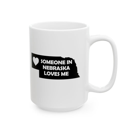 White mug with black text and heart design on a white background with text  Someone In Nebraska Loves Me