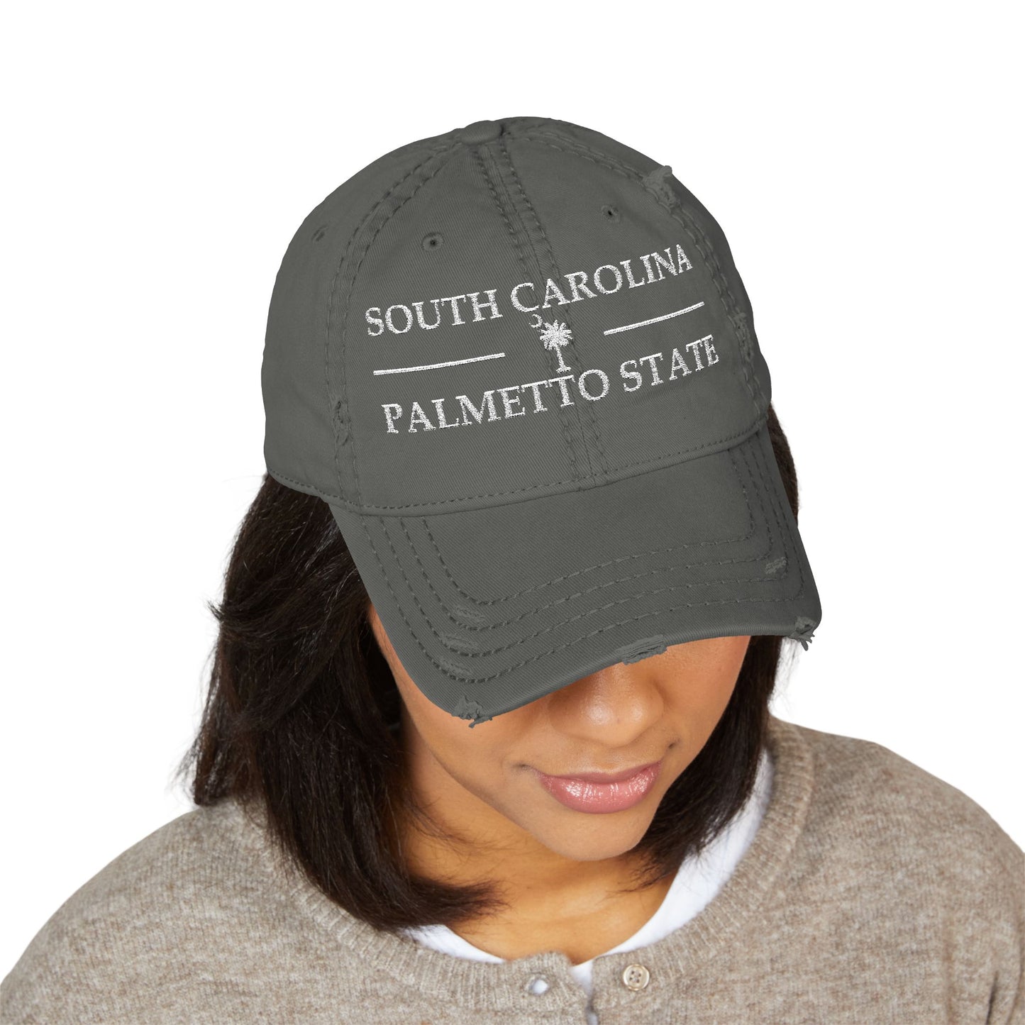 Person wearing a gray cap with 'South Carolina Palmetto State' text  embroidered in white thread