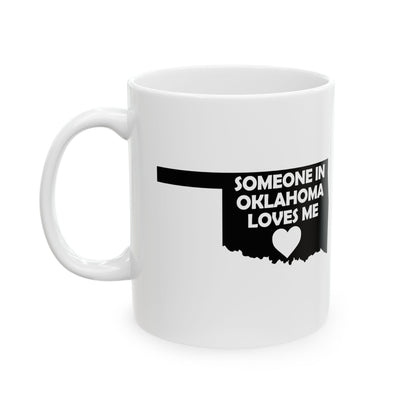 White mug with black text and heart design on a white background with text  Someone In Oklahoma Loves Me