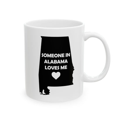 White mug with black silhouette of Alabama and text 'Someone in Alabama loves me' on a white background