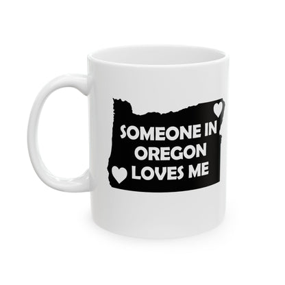 White mug with black design of Oregon map and text 'Someone in Oregon loves me' on a white background