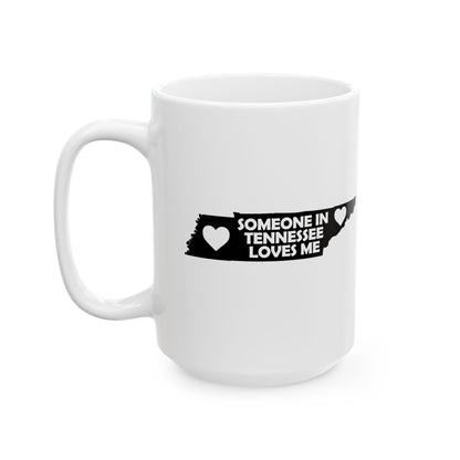 White mug with black text and heart design on a white background  with text  Someone In Tennessee Loves Me