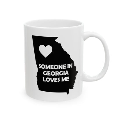 White mug with black silhouette of Georgia and heart, text 'Someone in Georgia loves me' on a white background
