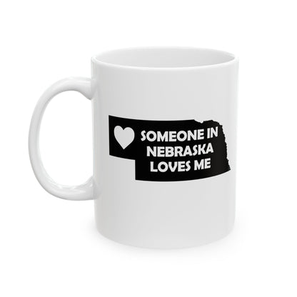 White mug with black text and heart design on a white background with text  Someone In Nebraska Loves Me