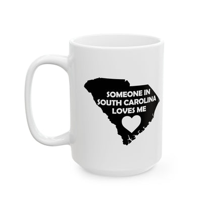 White mug with black silhouette of South Carolina and text 'Someone in South Carolina loves me' on a white background