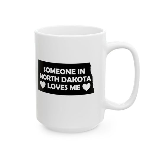 White mug with a black label reading 'Someone in North Dakota loves me' on a white background