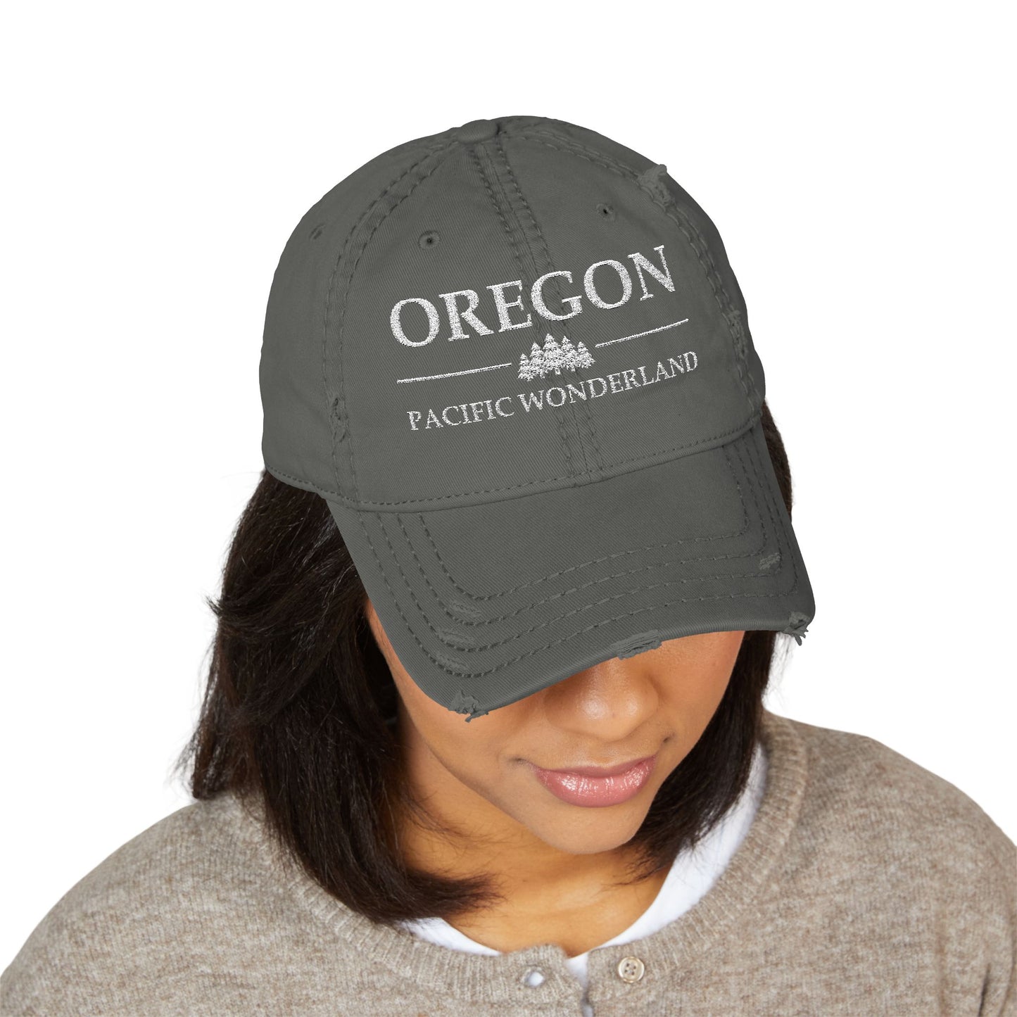 Person wearing a gray cap with 'OREGON PACIFIC WONDERLAND' text  embroidered in white thread