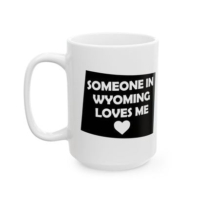 White mug with black text and heart design on a white background with text  Someone In Wyoming Loves Me