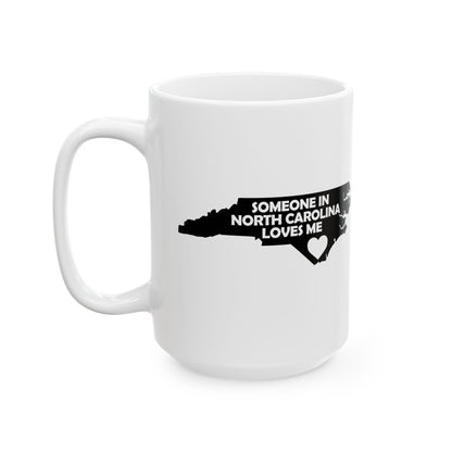 White mug with black text and North Carolina outline on a white background with text  Someone In North Carolina Loves Me